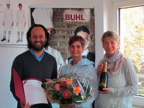 Gratulation zum 15-jährigen BUHL-Jubiläum: Frau Daniela Falkner (M.) erhält Blumen und Sekt von Eren Barlik (Regionalleiter) und Ina Radermacher (Personaldisponentin Service in Köln)