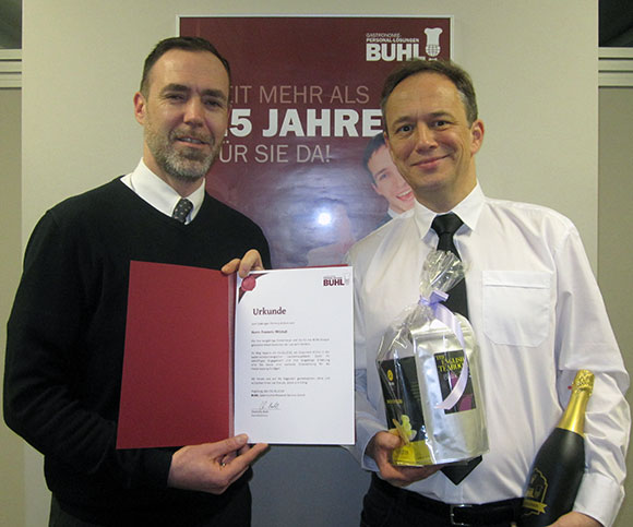 Regionalleiter Paul Müller (l.) ehrt seinen Mitarbeiter Frederic Mitzkat (r.) zum Jubiläum in Stuttgart