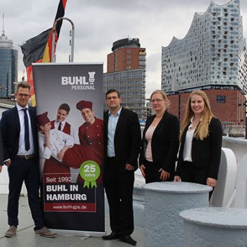 Team der Niederlassung Hamburg auf dem Museumsschiff „Cap San Diego“ vor der Kulisse der Elbphilharmonie (v.l.n.r.): Jennifer Burde (Personaldisponentin Service), Klaus Trautmann (Regionalleiter), Mirko Sibbersen (Fachbereichsleiter Küche), Fabian Baumann (Fachbereichsleiter Küche – Lübeck), Andrea Thurk (Teamassistentin), Katja Hillers (Personaldisponentin Service)